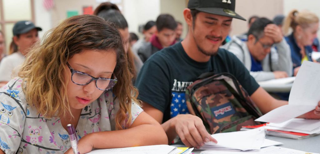 A photo of an ESL class, two students working on their assignment.