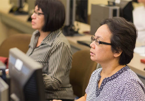 Two students working on computers in class.