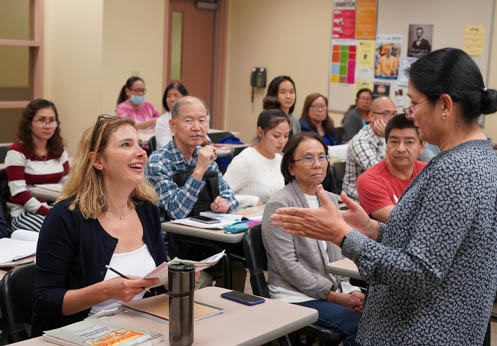 A photo of an NOCE student paying attention to her ESL teacher.