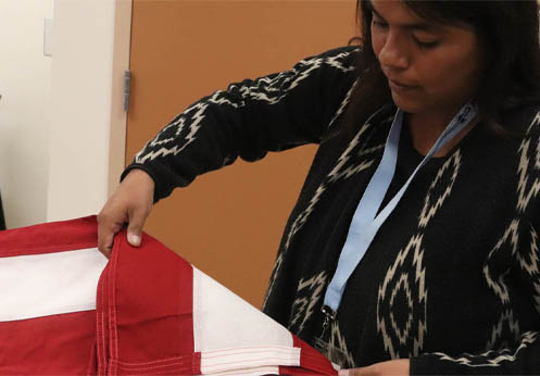 A funeral service student learning how to fold an American flag appropriately.