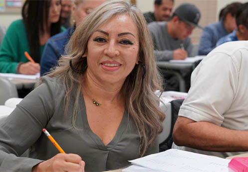 A smiling NOCE student with her pencil at hand, she was taking notes in class.