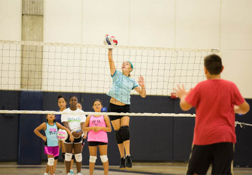 Kids and teens playing volleyball