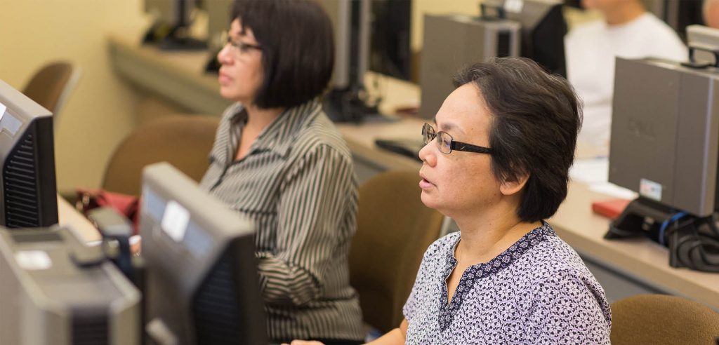 A photo of two students working on computers in class.