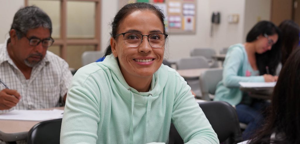 A photo of a smiling parenting student in class. 