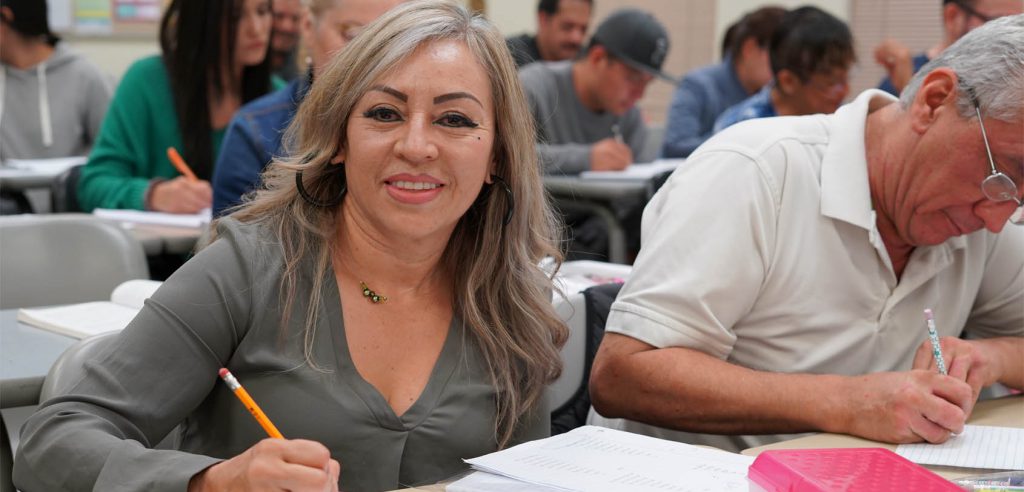 A photo of a smiling NOCE student with her pencil at hand, she was taking notes in class.