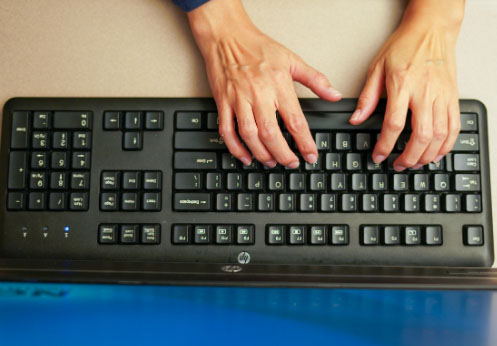 Student typing on keyboard in the Career Skills and Resource Lab