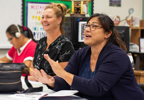 Parents laughing together in an in-person Love and Logic® class meeting.