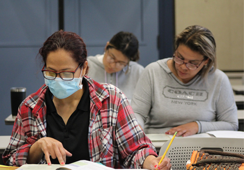 esl students in class reading their textbooks