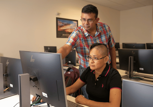 A teacher is helping a student navigate on their computer.