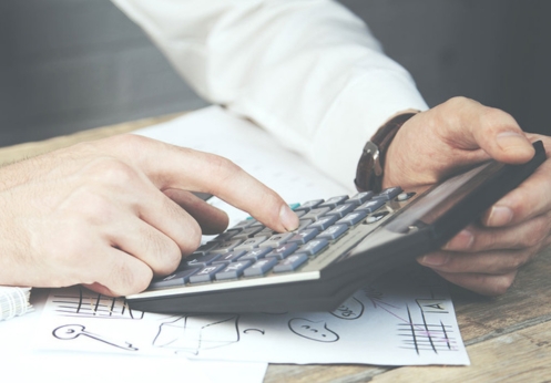 A tax professional holding and typing on a calculator.