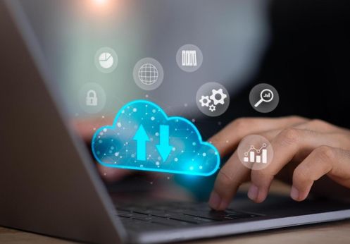 A graphic with a person typing and a digital cloud layered over the image.